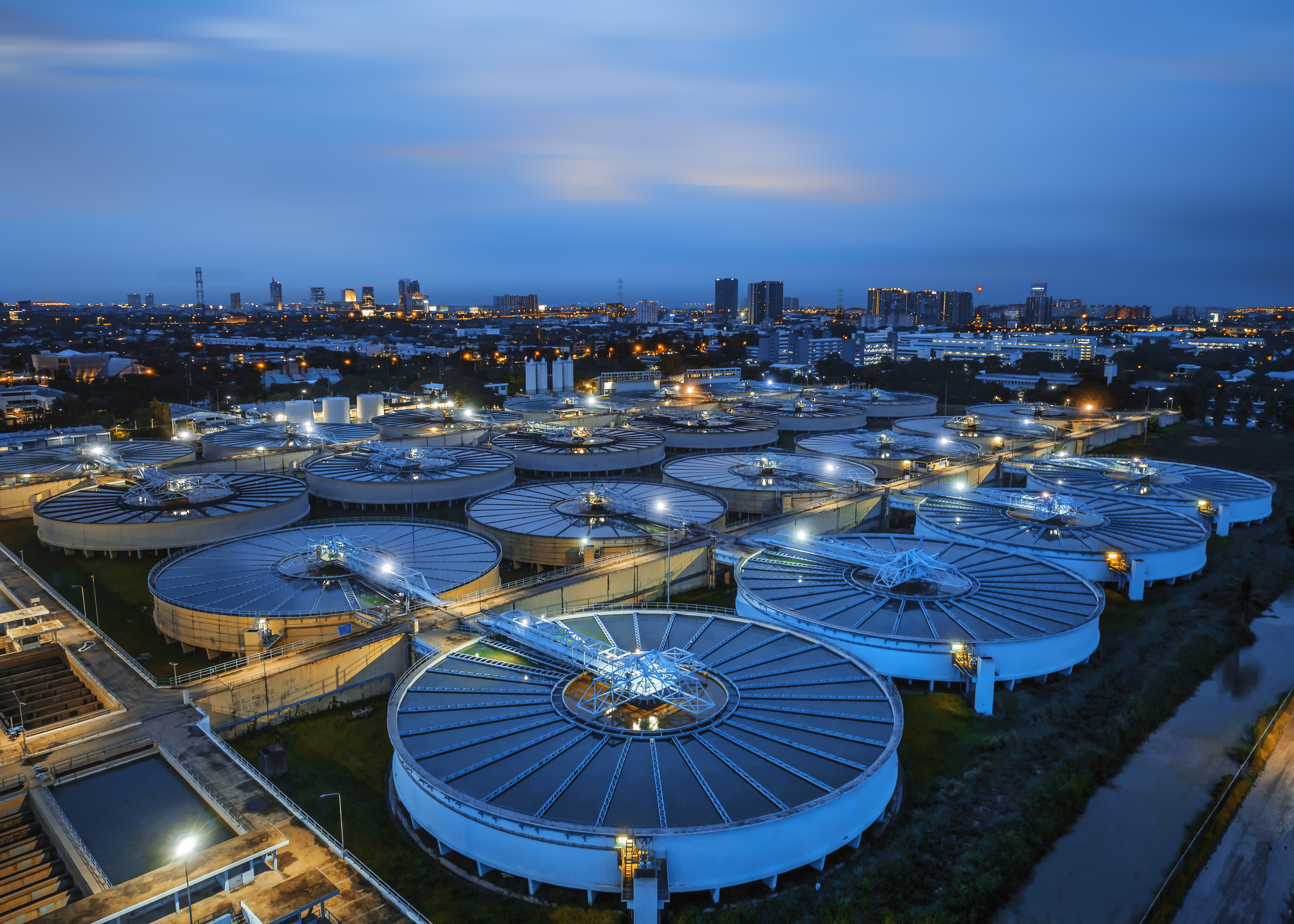 aerial view sewage treatment plant near downtown at night.